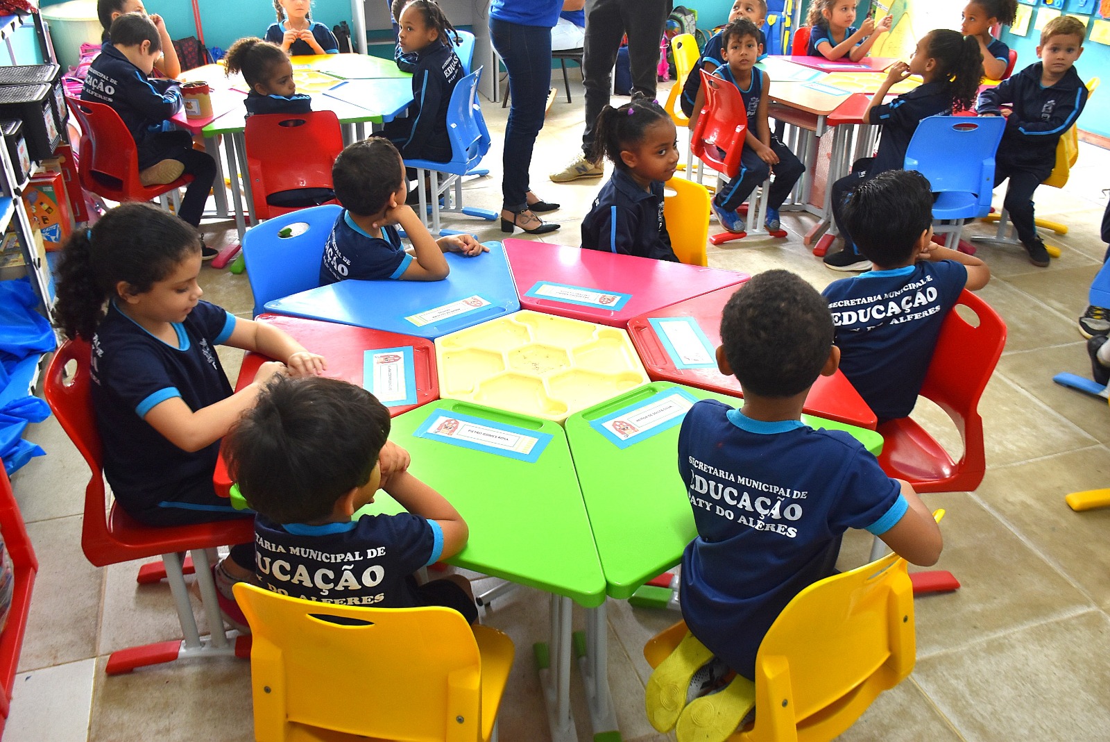 Escola primária, crianças ao redor de uma mesa.